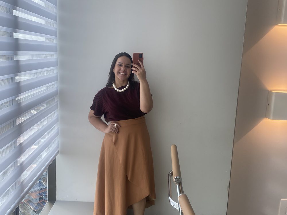 Mayara no consultório, em frente à janela